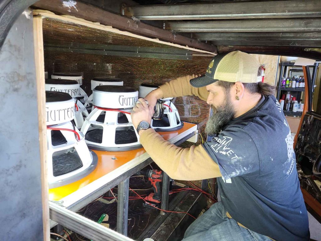 A technician from Audio Ace building a car speaker system