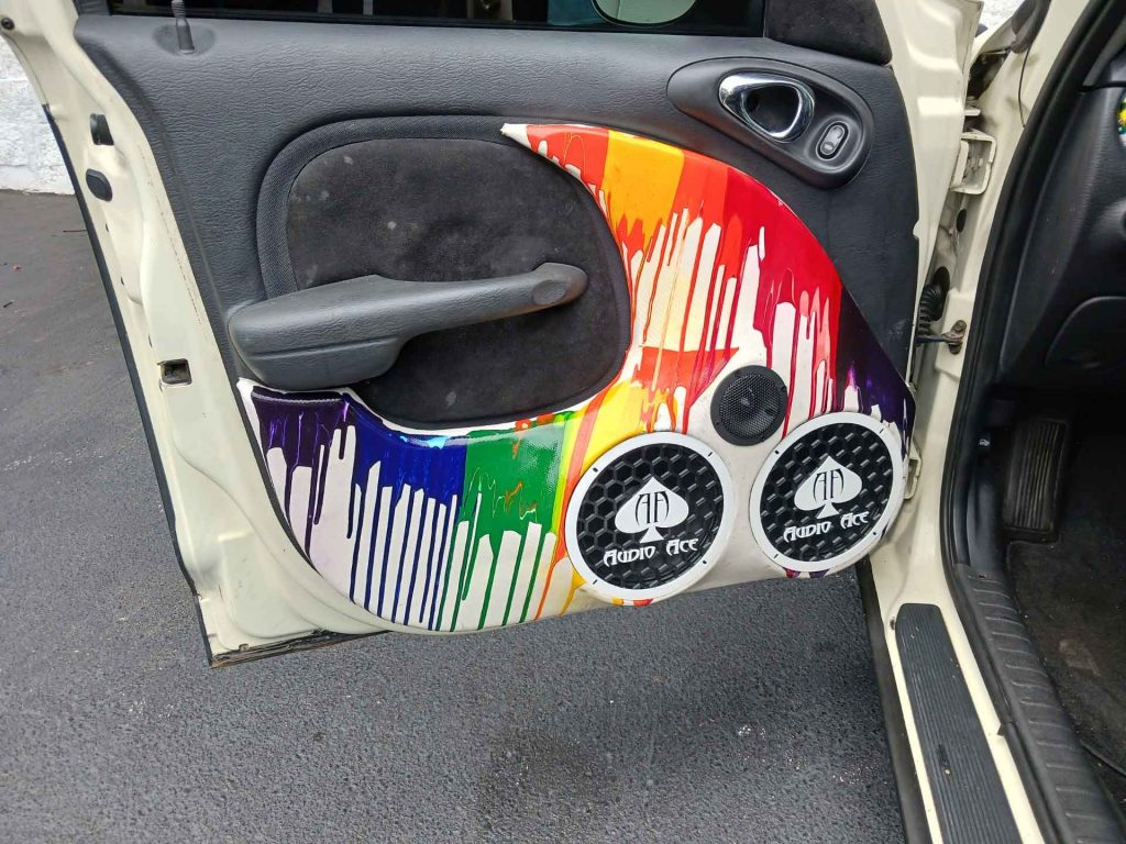 Interior of car door with rainbow paint job and audio system from Audio Ace